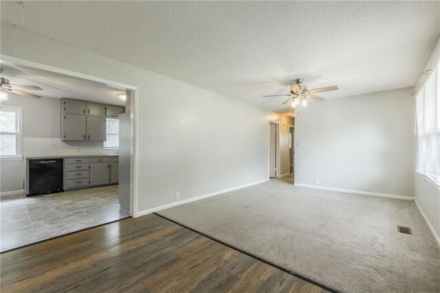 1221 Sunset St, Chillicothe, MO 64601 - unfurnished living room with a ceiling fan, plenty of natural light, light wood-type flooring, baseboards, and a textured ceiling