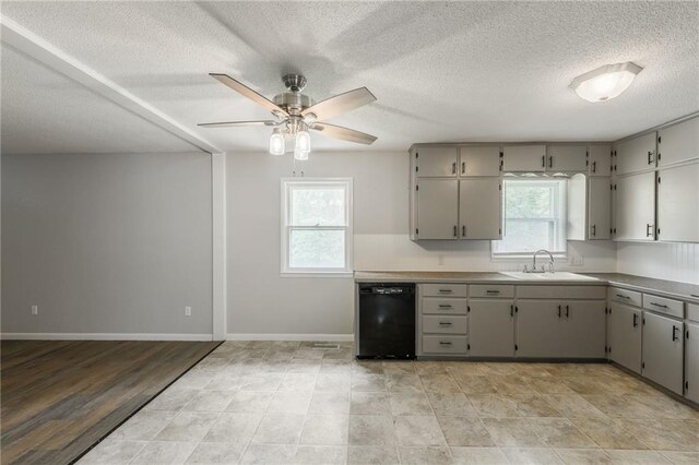 1221 Sunset St, Chillicothe, MO 64601 - kitchen featuring dishwasher, a sink, gray cabinetry, ceiling fan, and a textured ceiling