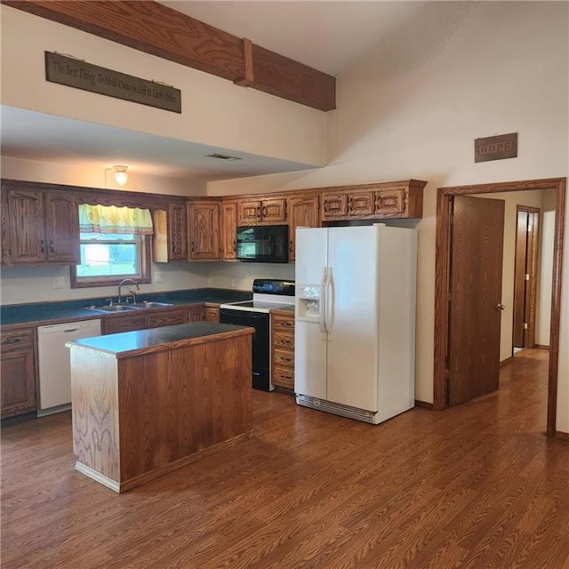 411 Briarwood Dr, Iola, KS 66749 - kitchen with white appliances, a sink, dark wood-type flooring, a center island, and a high ceiling