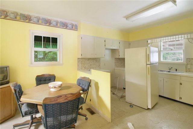 1601 Stevens Ave, Parsons, KS 67357 - kitchen featuring freestanding refrigerator, a sink, tasteful backsplash, and light countertops