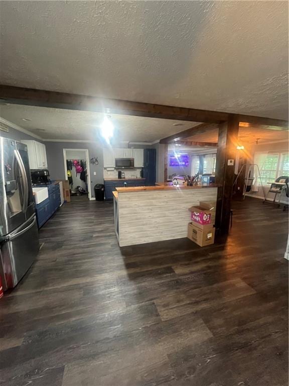 933 1300th St, Iola, KS 66749 - living room featuring a textured ceiling, dark wood finished floors, and beam ceiling