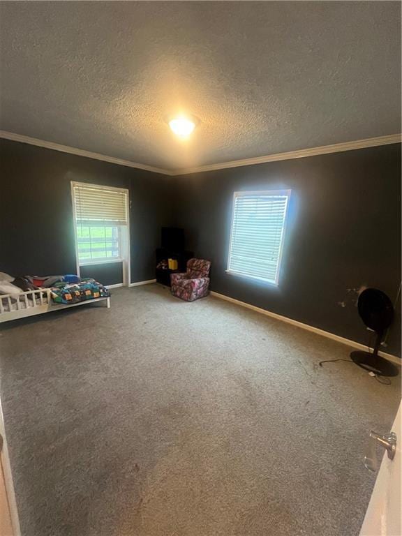933 1300th St, Iola, KS 66749 - unfurnished bedroom featuring crown molding, a textured ceiling, carpet floors, and baseboards