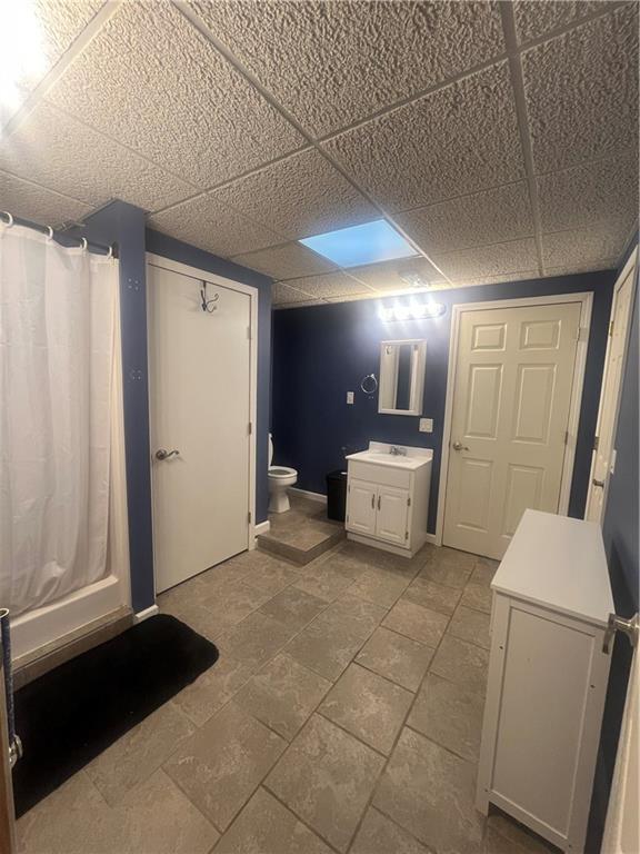 933 1300th St, Iola, KS 66749 - full bathroom featuring vanity, a paneled ceiling, and toilet