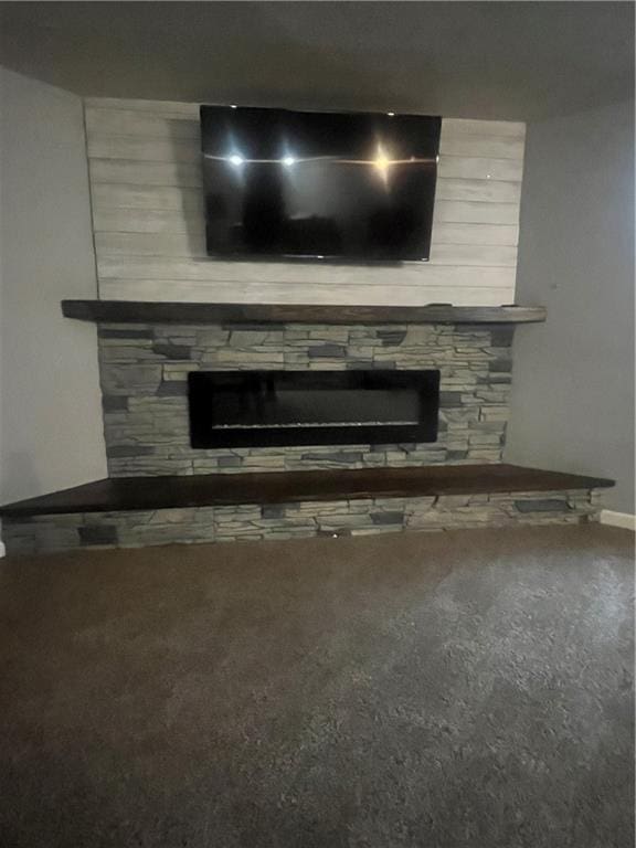 933 1300th St, Iola, KS 66749 - detailed view of a fireplace, carpet, and baseboards