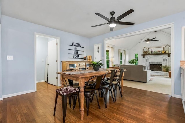 33991 Mission Belleview Rd, Louisburg, KS 66053 - dining room with ceiling fan, a fireplace, wood finished floors, baseboards, and vaulted ceiling