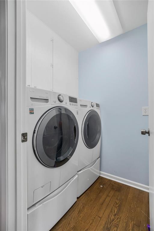 33991 Mission Belleview Rd, Louisburg, KS 66053 - washroom featuring washer and dryer, dark wood-style flooring, baseboards, and cabinet space