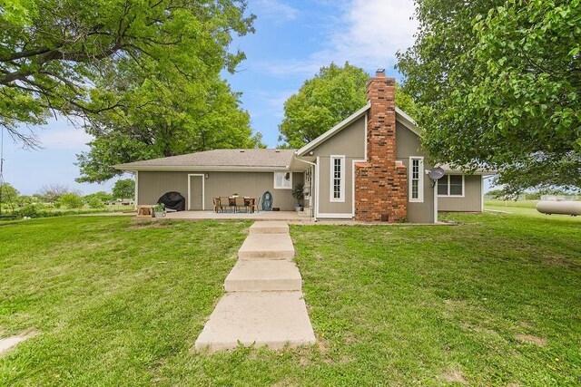 33991 Mission Belleview Rd, Louisburg, KS 66053 - back of house featuring a chimney, a patio area, and a lawn
