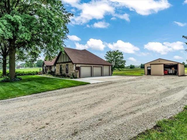 12806 33rd Hwy, Kearney, MO 64060 - view of front of house with driveway, a front yard, a detached garage, board and batten siding, and stone siding