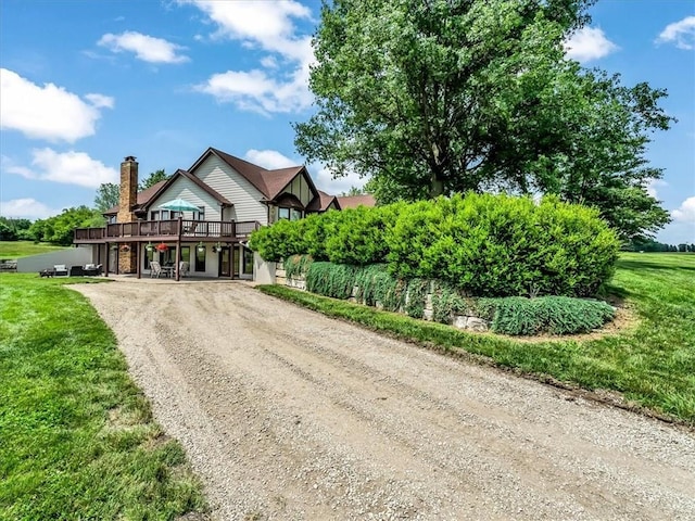 12806 33rd Hwy, Kearney, MO 64060 - view of front facade featuring driveway, a deck, a front lawn, and a chimney