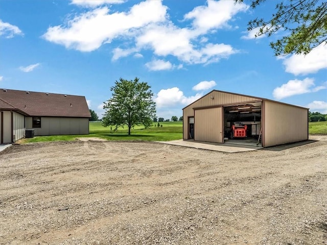 12806 33rd Hwy, Kearney, MO 64060 - view of yard featuring a garage, a pole building, an outbuilding, driveway, and central AC