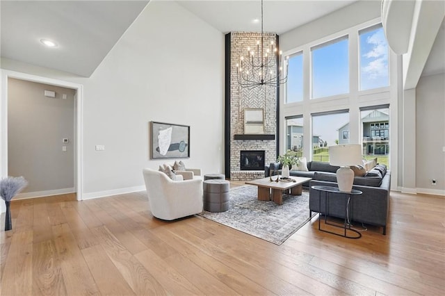 17137 Barton St, Overland Park, KS 66221 - living room with a towering ceiling, a chandelier, light wood-type flooring, and baseboards