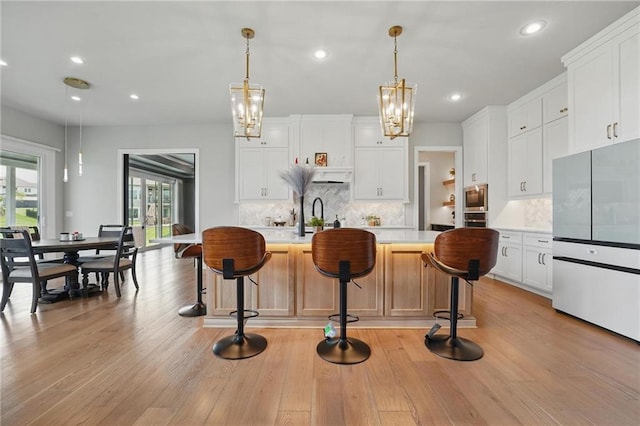 17137 Barton St, Overland Park, KS 66221 - kitchen featuring appliances with stainless steel finishes, light countertops, decorative backsplash, a chandelier, and hanging light fixtures