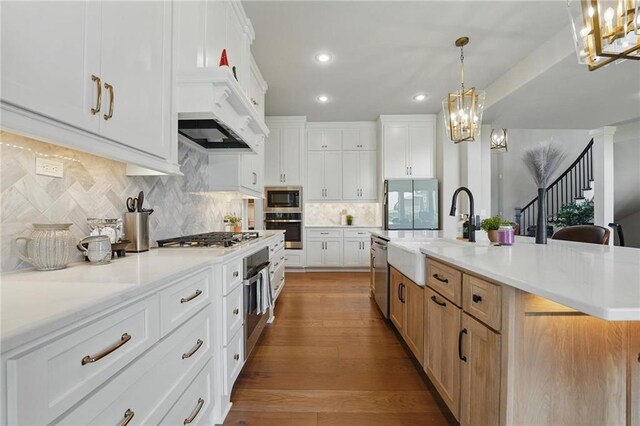 17137 Barton St, Overland Park, KS 66221 - kitchen featuring appliances with stainless steel finishes, a sink, light countertops, tasteful backsplash, and recessed lighting
