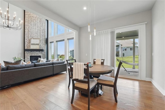 17137 Barton St, Overland Park, KS 66221 - dining space with healthy amount of natural light, light wood-type flooring, a chandelier, a fireplace, and recessed lighting