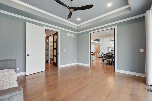 17137 Barton St, Overland Park, KS 66221 - living room featuring a ceiling fan, wood finished floors, baseboards, a tray ceiling, and crown molding