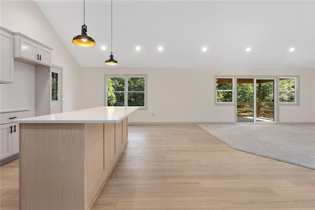 38 NW 525th Rd, Warrensburg, MO 64093 - kitchen featuring vaulted ceiling, light countertops, open floor plan, a kitchen island, and light wood finished floors