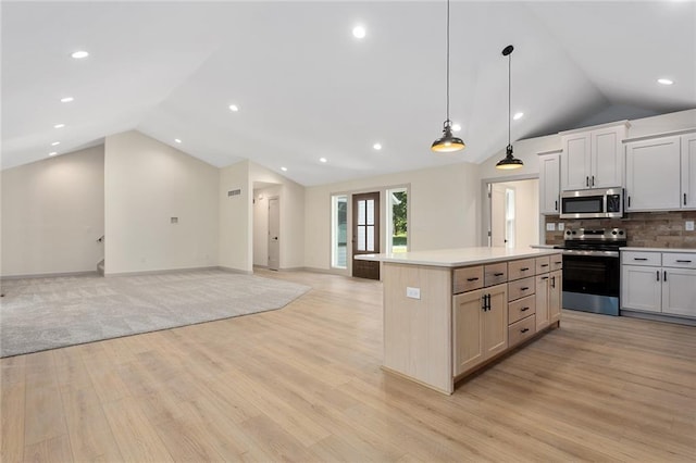 38 NW 525th Rd, Warrensburg, MO 64093 - kitchen featuring stainless steel appliances, vaulted ceiling, open floor plan, light wood-type flooring, and light countertops