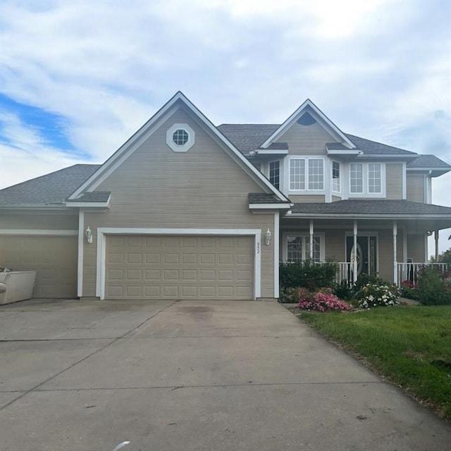 952 NW Maplewood Ct, Grain Valley, MO 64029 - view of front facade featuring driveway, an attached garage, a porch, and a shingled roof