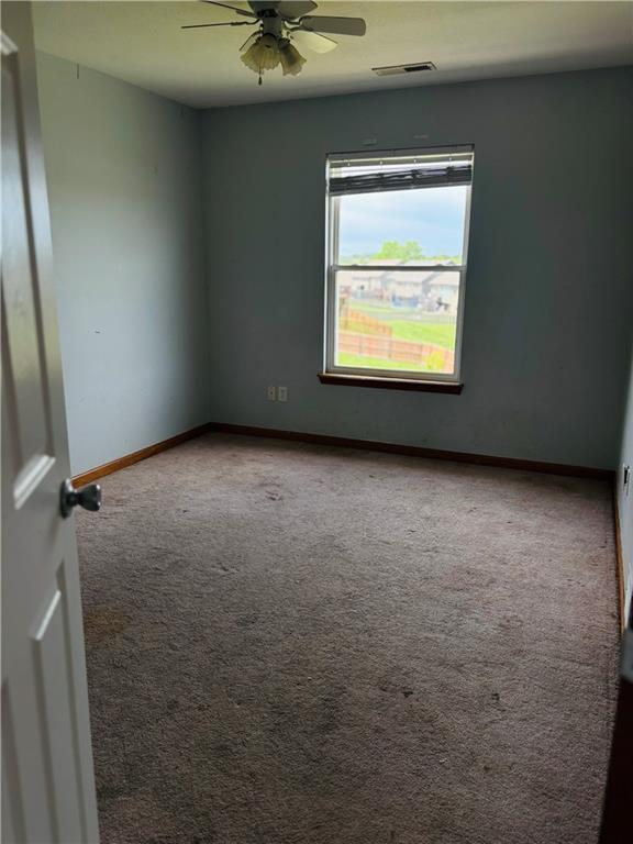 952 NW Maplewood Ct, Grain Valley, MO 64029 - carpeted spare room featuring ceiling fan and baseboards
