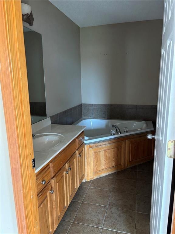 952 NW Maplewood Ct, Grain Valley, MO 64029 - bathroom featuring a jetted tub, vanity, and tile patterned flooring