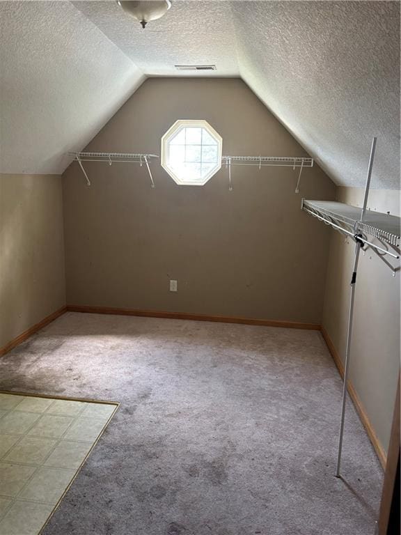 952 NW Maplewood Ct, Grain Valley, MO 64029 - bonus room featuring a textured ceiling, light carpet, lofted ceiling, and baseboards