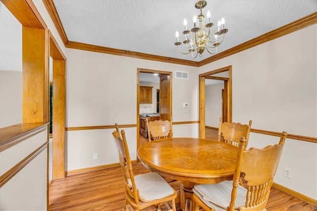 4506 NW Apache Dr, Riverside, MO 64150 - dining area with a textured ceiling, a chandelier, baseboards, light wood-type flooring, and crown molding