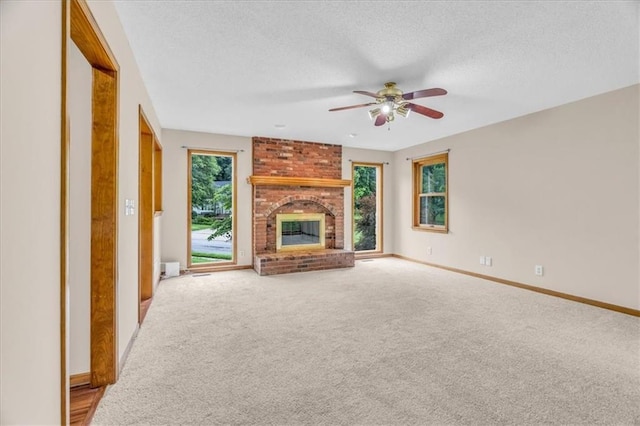4506 NW Apache Dr, Riverside, MO 64150 - unfurnished living room featuring ceiling fan, carpet floors, a brick fireplace, a textured ceiling, and baseboards
