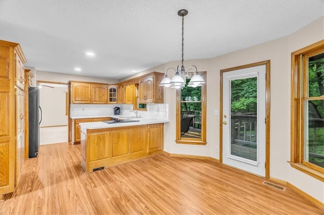 4506 NW Apache Dr, Riverside, MO 64150 - kitchen with a peninsula, light wood-style flooring, light countertops, healthy amount of natural light, and recessed lighting