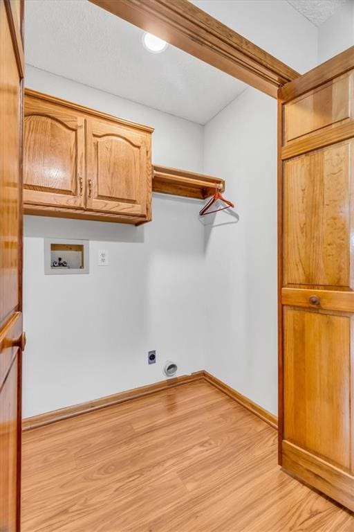 4506 NW Apache Dr, Riverside, MO 64150 - laundry room featuring cabinet space, hookup for a washing machine, electric dryer hookup, light wood finished floors, and baseboards