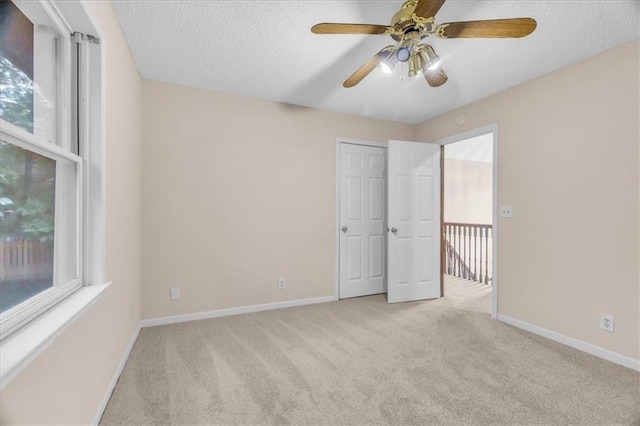 4506 NW Apache Dr, Riverside, MO 64150 - unfurnished bedroom with carpet flooring, multiple windows, a textured ceiling, and baseboards