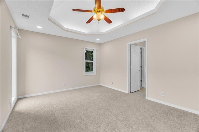 4506 NW Apache Dr, Riverside, MO 64150 - empty room with light carpet, ceiling fan, baseboards, a tray ceiling, and recessed lighting