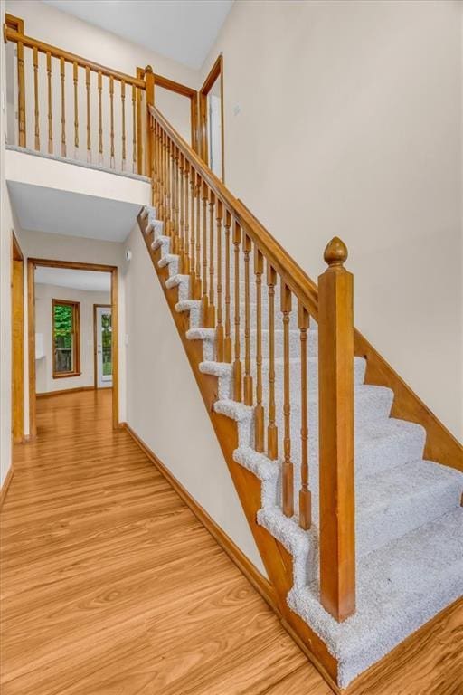 4506 NW Apache Dr, Riverside, MO 64150 - stairway with wood finished floors, baseboards, and a high ceiling