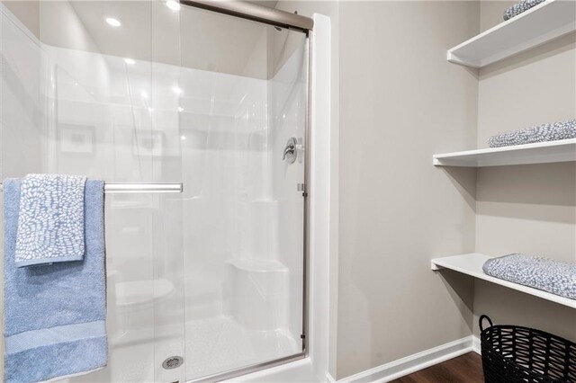 37838 W 208th Ter, Edgerton, KS 66021 - bathroom with a shower stall, baseboards, wood finished floors, and recessed lighting