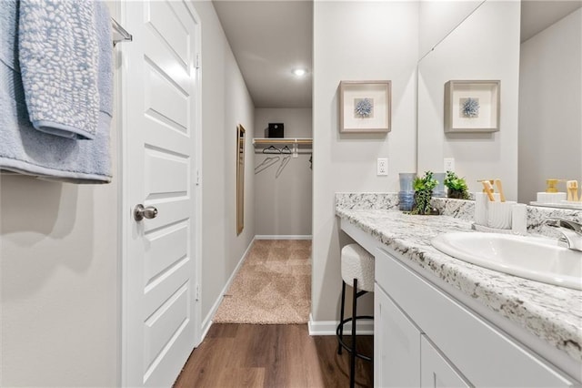37838 W 208th Ter, Edgerton, KS 66021 - bathroom with vanity, baseboards, wood finished floors, recessed lighting, and a walk in closet