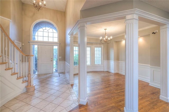 5706 NE Sapphire Pl, Lees Summit, MO 64064 - entryway with a chandelier, a decorative wall, stairway, decorative columns, and a wainscoted wall