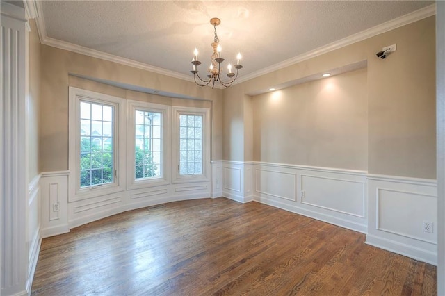5706 NE Sapphire Pl, Lees Summit, MO 64064 - empty room with a chandelier, dark wood-style floors, ornamental molding, a textured ceiling, and a wainscoted wall