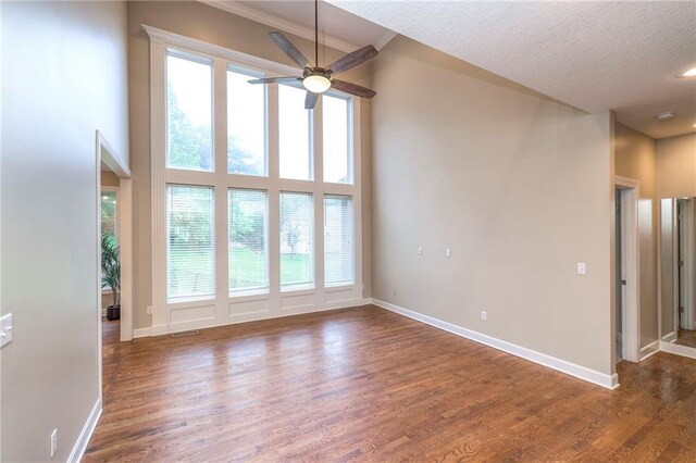5706 NE Sapphire Pl, Lees Summit, MO 64064 - unfurnished living room featuring plenty of natural light, a ceiling fan, wood finished floors, baseboards, and a textured ceiling