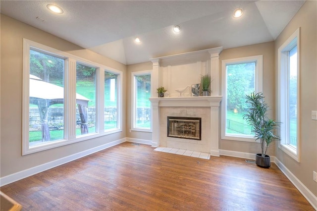 5706 NE Sapphire Pl, Lees Summit, MO 64064 - unfurnished living room featuring wood finished floors, baseboards, vaulted ceiling, a tiled fireplace, and recessed lighting