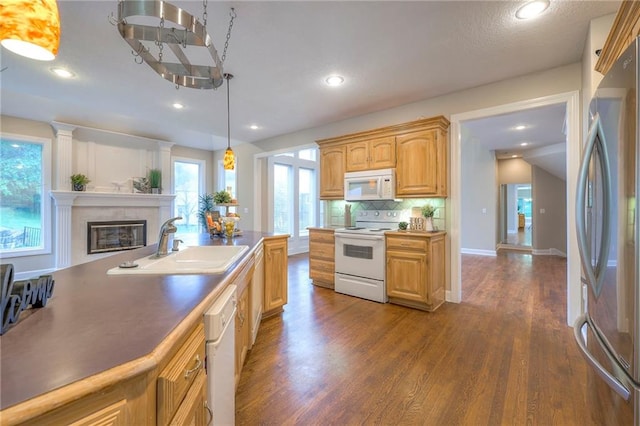 5706 NE Sapphire Pl, Lees Summit, MO 64064 - kitchen featuring white appliances, a sink, a glass covered fireplace, dark wood-type flooring, and backsplash