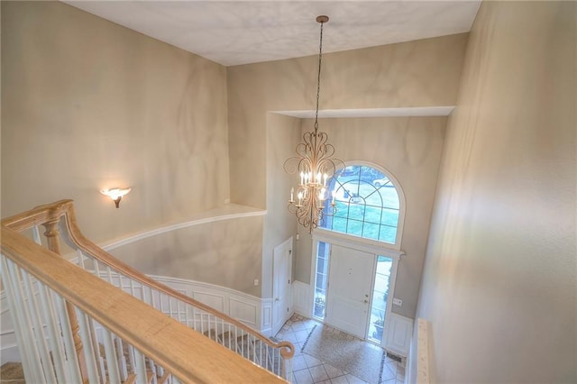 5706 NE Sapphire Pl, Lees Summit, MO 64064 - entrance foyer featuring a chandelier, a decorative wall, stairway, and a towering ceiling