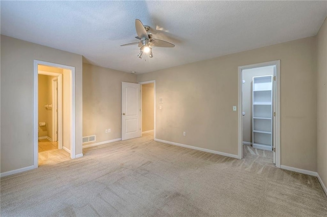5706 NE Sapphire Pl, Lees Summit, MO 64064 - unfurnished bedroom with a spacious closet, baseboards, carpet flooring, and connected bathroom