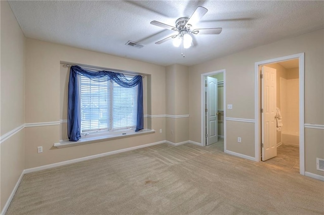 5706 NE Sapphire Pl, Lees Summit, MO 64064 - unfurnished bedroom featuring carpet, a spacious closet, baseboards, a textured ceiling, and ensuite bathroom