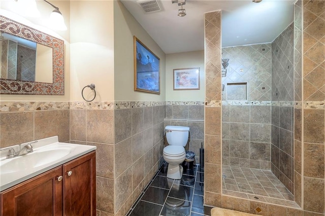 5706 NE Sapphire Pl, Lees Summit, MO 64064 - full bathroom with toilet, vanity, tile walls, tiled shower, and a wainscoted wall