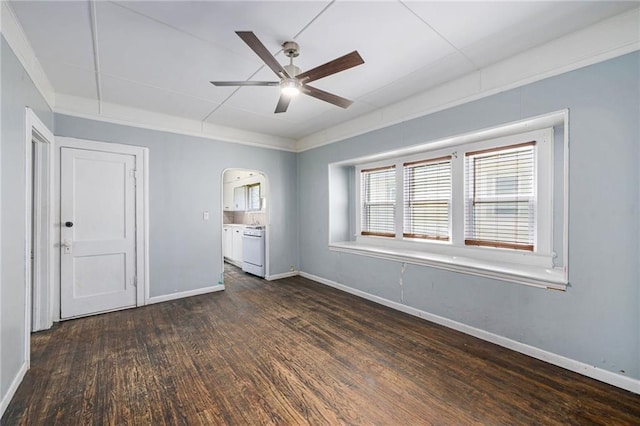 1409 N 24th St, Kansas City, KS 66102 - empty room featuring a ceiling fan, dark wood-type flooring, arched walkways, baseboards, and crown molding