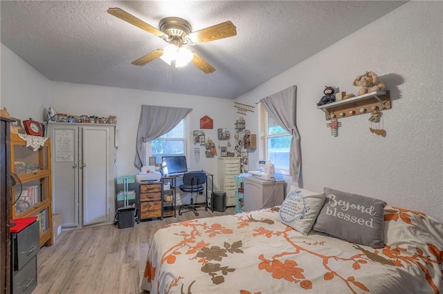 25801 E 317th Ter, Harrisonville, MO 64701 - bedroom with light wood-style flooring, a textured ceiling, multiple windows, a ceiling fan, and a textured wall