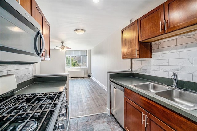 600 E 8th St Unit 6N, Kansas City, MO 64106 - kitchen with stainless steel appliances, dark countertops, a sink, decorative backsplash, and ceiling fan