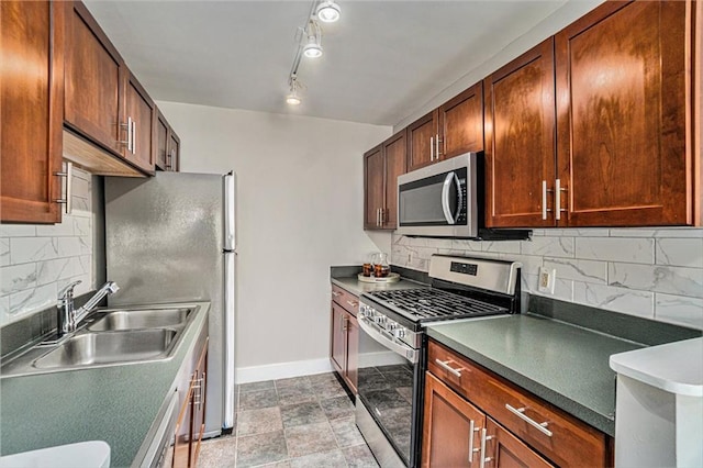600 E 8th St Unit 6N, Kansas City, MO 64106 - kitchen featuring stainless steel appliances, a sink, baseboards, backsplash, and dark countertops