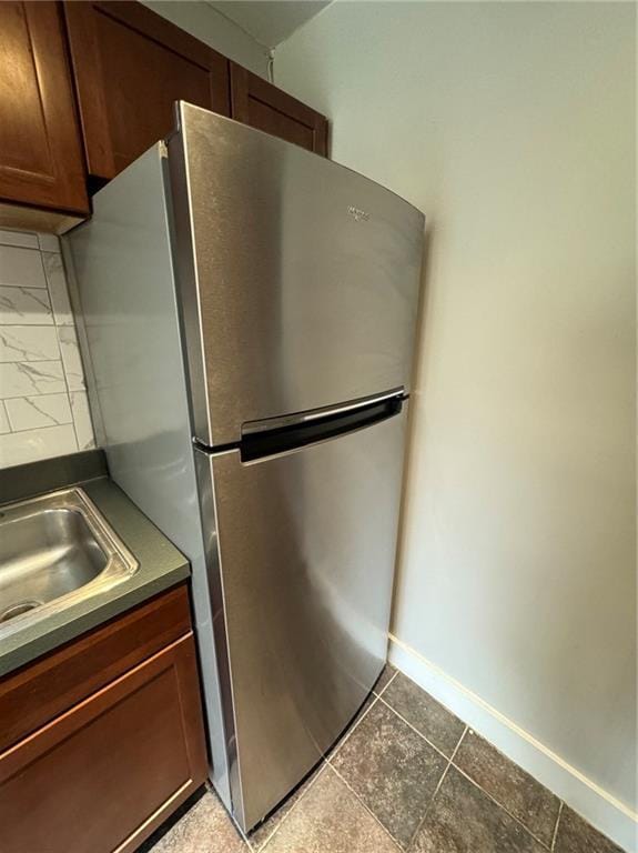 600 E 8th St Unit 6N, Kansas City, MO 64106 - kitchen with freestanding refrigerator, baseboards, a sink, dark tile patterned flooring, and dark countertops