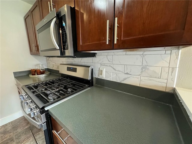600 E 8th St Unit 6N, Kansas City, MO 64106 - kitchen with stainless steel appliances, decorative backsplash, dark countertops, and baseboards