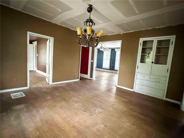 1202 Wall St, Galena, KS 66739 - unfurnished dining area with a chandelier, wood finished floors, and baseboards